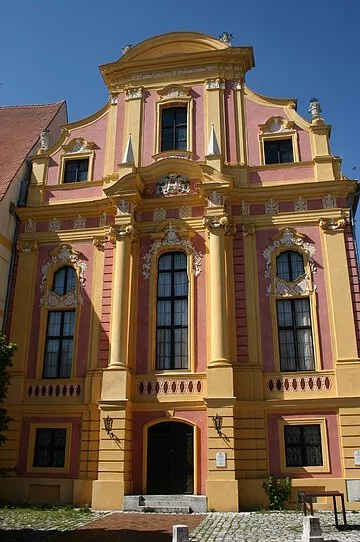 Staatliche Provinzialbibliothek Die Staatliche Provinzialbibliothek von außen fotografiert. Das Gebäude im Frührokokobaustil mit seiner reichen Fassadengliederung in rosa und gelber Farbe gehalten.