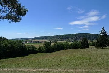 Grüne Wiesen und Bäume sieht man bei dem Ausblick über die Mauerner Höhlen.