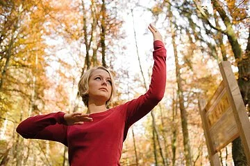 Eine Frau zeigt eine QiGong-Übung im Freien