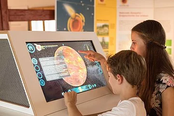 Infoterminal im Geopark Infozentrum Nördlingen Zwei Kinder schauen sich die Infomationen auf dem Infoterminal im Geopark Infozentrum in Nördlingen an