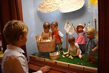 Puppenszene im Käthe-Kruse-Puppenmuseum in Donauwörth Ein Junge betrachtet eine Puppenszene im Käthe Kruse Puppenmuseum.