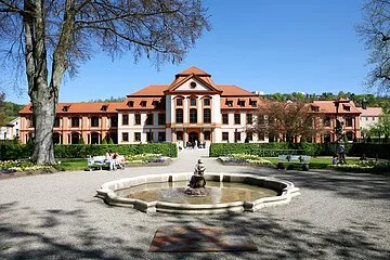 In der Mitte des Bildes befindet sich die Sommerresidenz des Eichstätter Hofgartens. Das mehrstöckige Residenzgebäude erstreckt sich quer über das ganze Bild. Der Anstrich des Gebäudes ist weiß und bildet somit einen Kontrast zu den orangen umrandeten Fenstern und Türen sowie den mit roten Ziegeln bedeckten Dach. Davor liegt ein Brunnen mit einer wasserspeienden Skulptur. Der Brunnen wird von einem Kiesweg, der auf das Residenzgebäude zuführt, umrandet. Rechts und links sind Grünflächen, die mit Bäumen, Hecken und Blumen bepflanzt sind.