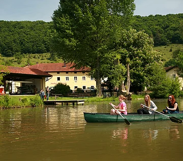 Gasthof zum Hollerstein in Zimmern Im Vordergrund Altmühl mit Boot, dahinter Gasthof zum Hollerstein in Zimmern