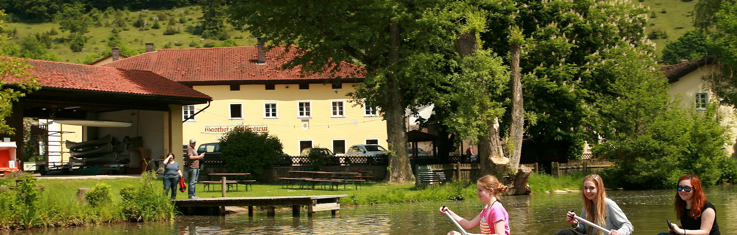 Im Vordergrund Altmühl mit Boot, dahinter Gasthof zum Hollerstein in Zimmern