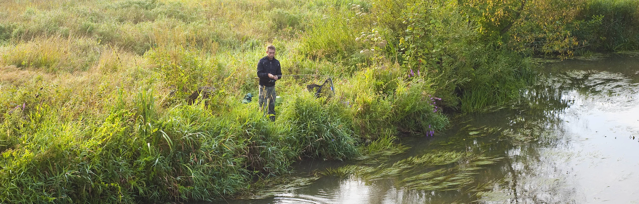 Das Foto zeigt einen Angler beim Fischen an der Schwarzach