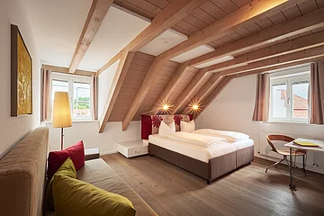 Ein Schlafzimmer mit Doppelbett in Naturfarbtönen eingerichtet.