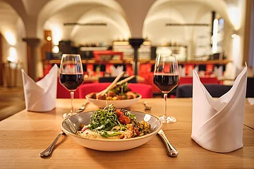 Das schön angerichtete Gericht mit Rotwein steht im Fokus.