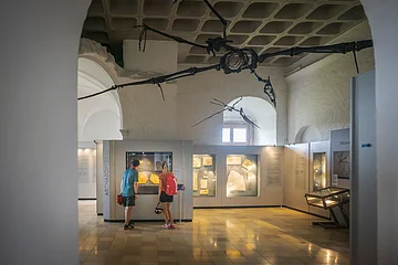 Jura-Museum in Eichstätt Zwei Personen betrachten Fossilien in einem Museum, über ihnen hängt ein großes Flugsaurierskelett.