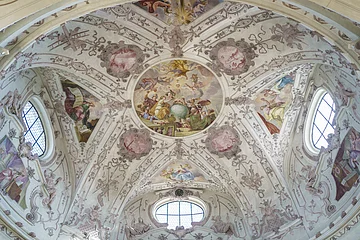 Deckengemälde der Klosterkirche Notre Dame Deckenfresko mit religiösen Szenen und Ornamenten in einer Kirche, umgeben von Fenstern und Stuckverzierungen.