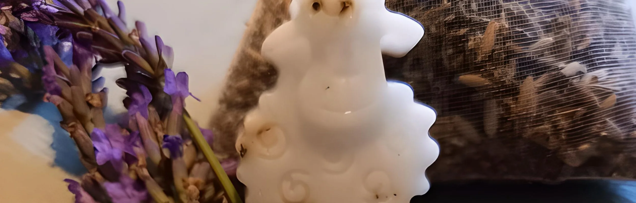 Eine Lavendelseife in Schäfchenform liegt auf einem Tisch, dekoriert mit blühendem Lavendel