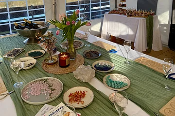 Schön dekorierter Tisch mit Blumen, Perlen und Prosecco