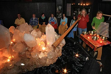 Kristallmuseum mit Besuchern und zwei Musikern mit Klangistrumenten