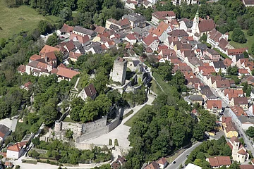 Die Burg Pappenheim von oben aufgenommen. Man hat einen guten Blick auf die gesamte Anlage mit Garten und Bäumen. Rechts sind auch viele Pappenheimer Häuser zu sehen.