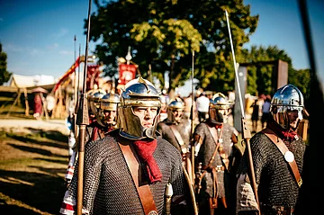 Römertage Abusina Gruppe von Menschen in römischer Rüstung mit Helmen und Speeren bei einem historischen Nachstellen im Freien.