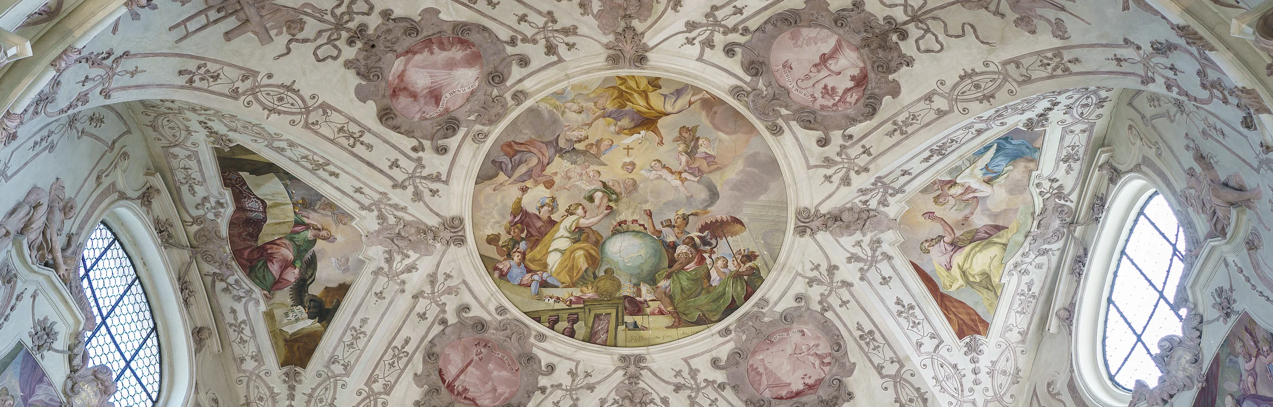 Deckenfresko mit religiösen Szenen und Ornamenten in einer Kirche, umgeben von Fenstern und Stuckverzierungen.