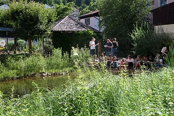 Schulklasse am Teich im Biotopgarten